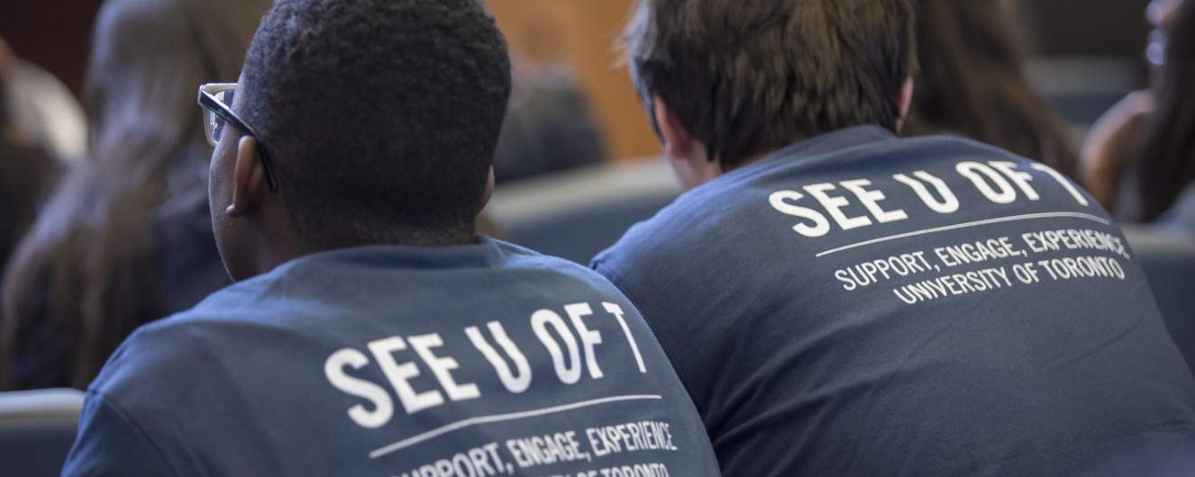 Students wearing SEE U of T t-shirts sit in class.