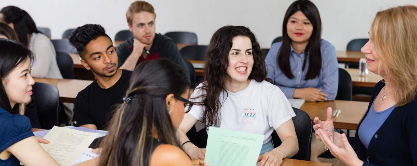 Small group of students having a discussion with an instructor in the classroom