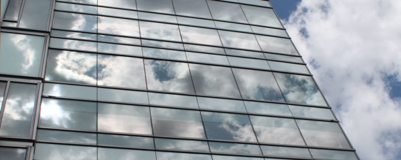 A photo of the residence tower with clouds reflected in the glass