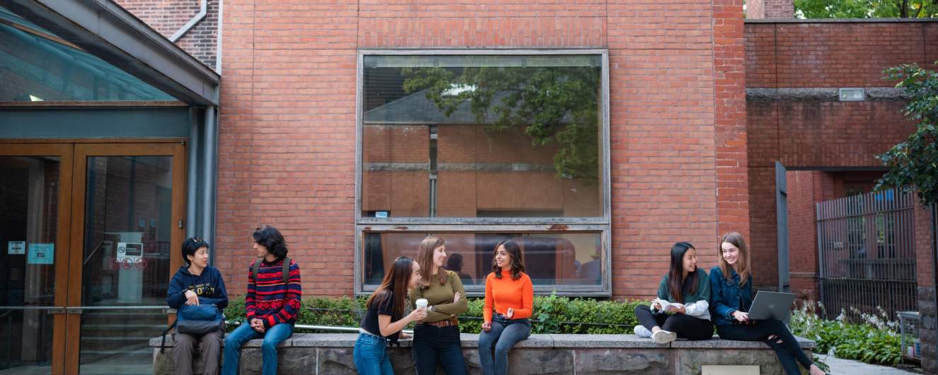 Groups of students sitting and standing around Woodsworth College.