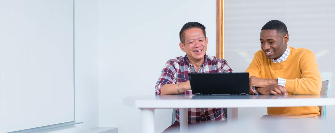 Two students in the Academic Bridging Program working together on a laptop