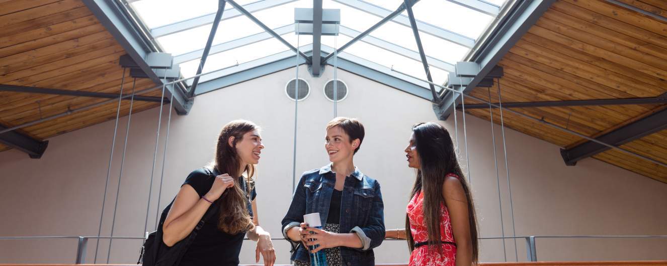 Three students talking under the skylight above Kruger Hall