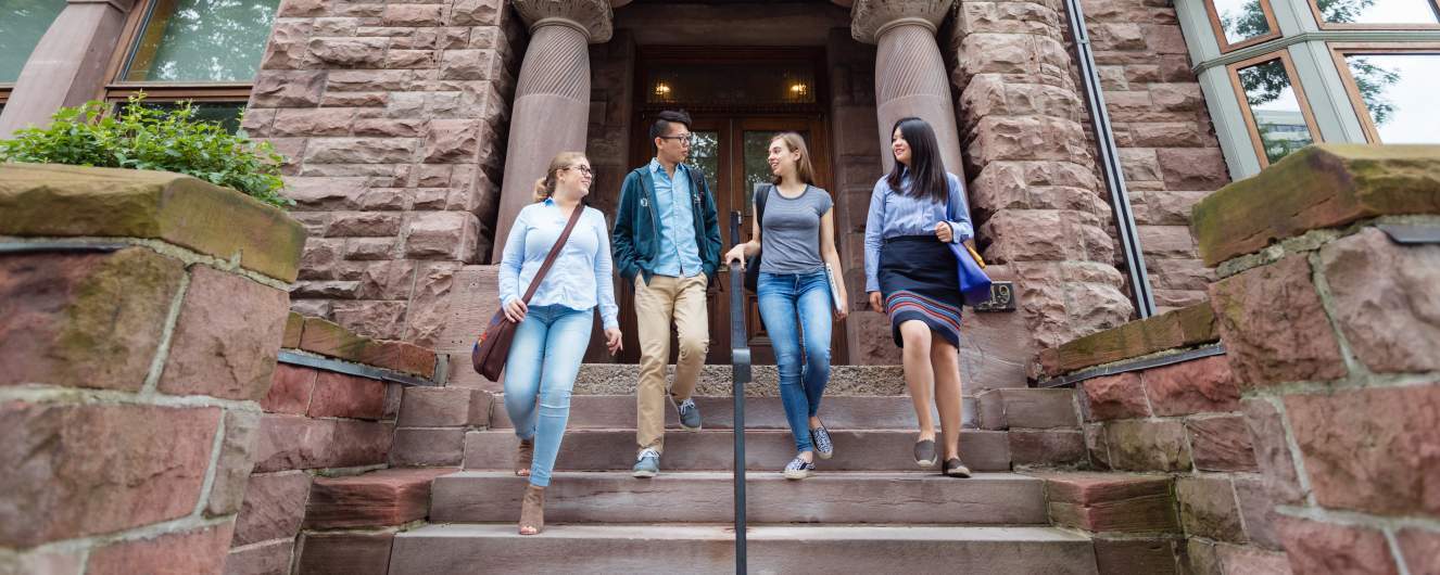Four students walking down front steps of Woodsworth College
