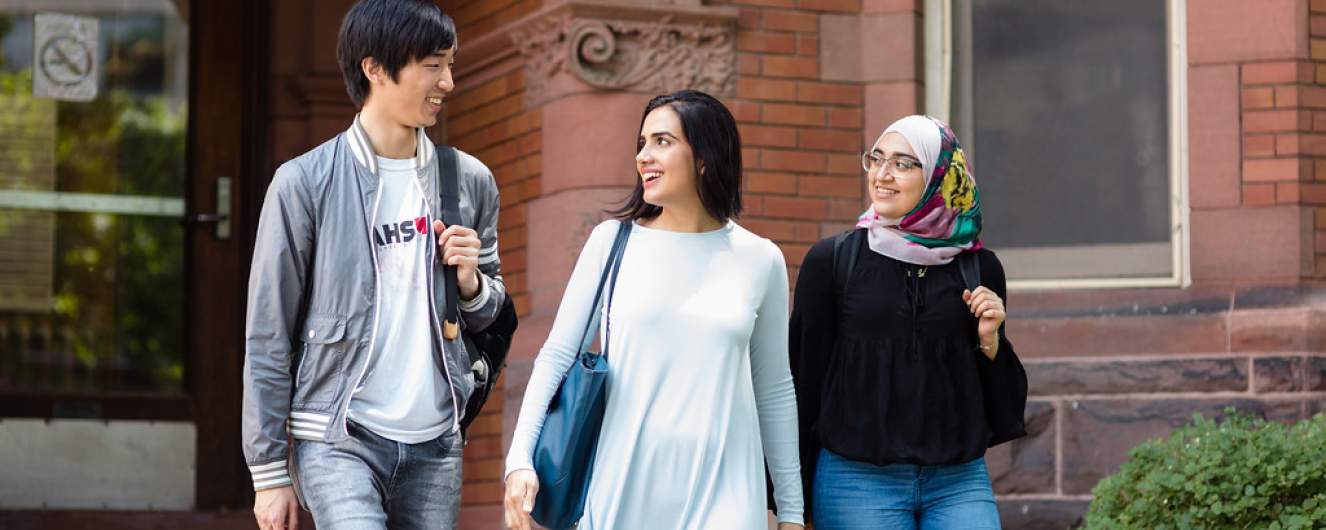 Three students walking in front of 123 St. George Street