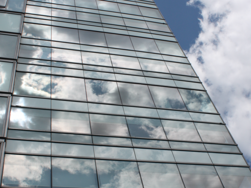 A photo of the residence tower with clouds reflected in the glass