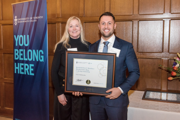 Award presenter and recipient holding the framed award certificate
