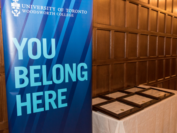 A large Woodsworth College banner beside a table with awards