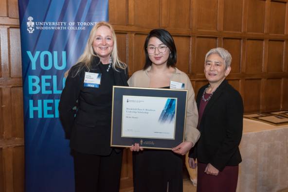 Blythe (middle) stands with Lynda Hamilton (left) and Principal Chin (right), holding her award certificate.