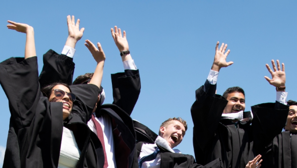 Students in Convocation Gowns jumping
