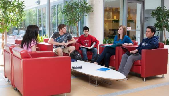 Five residents sitting on leather sofas in the residence lobby.