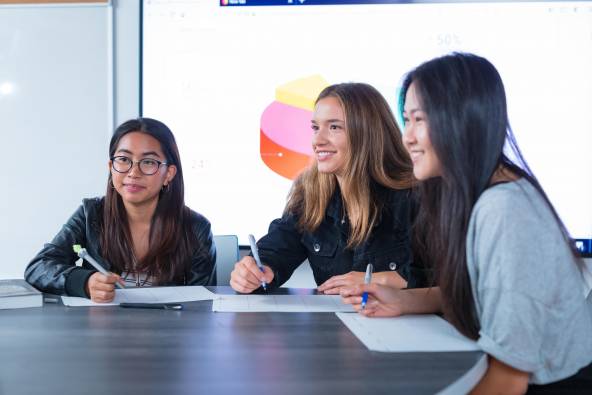 Three students working together in a classroom