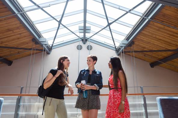 Three students talking under the skylight above Kruger Hall