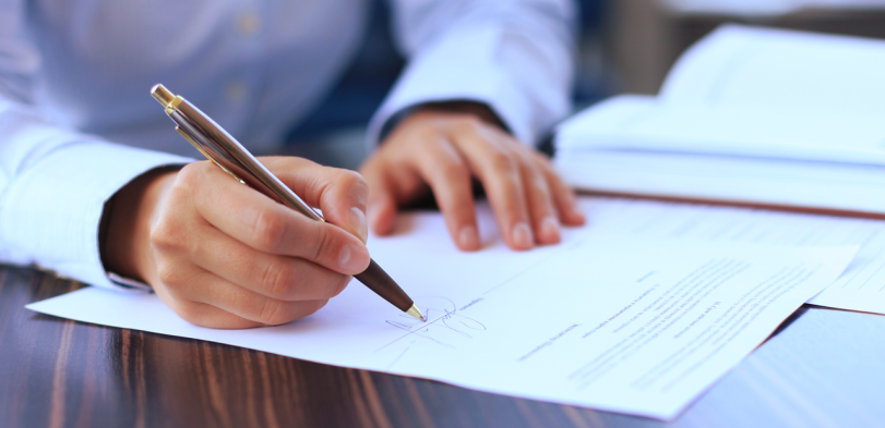 Image of a person signing a document